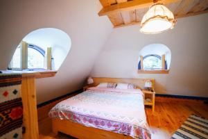 a bedroom with two arched windows and a bed at Casa lu' Ion in Vişeu de Sus