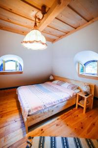 a bedroom with a bed and two windows at Casa lu' Ion in Vişeu de Sus