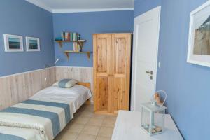 a bedroom with two beds and a blue wall at Dom Rybaka apartament 4 in Ustka