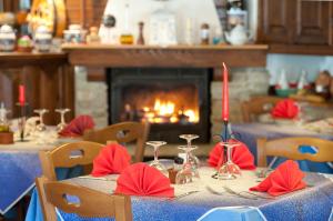 a table with red napkins and candles on it with a fireplace at Hotel Palavas in Villar Pellice