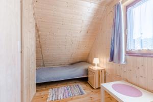 een kleine kamer met een bed in een tiny house bij Aurum domki in Jarosławiec