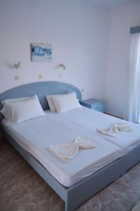 - un lit avec des draps blancs et des oreillers blancs dans l'établissement Sevoula studios, à Kefalos