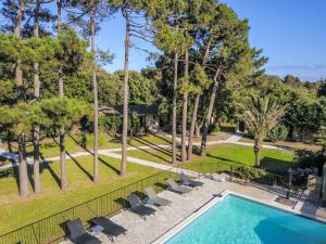 a swimming pool with chairs and a fence and trees at Prea Gianca in Bonifacio