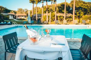 a table with a bottle of wine on it next to a pool at Prea Gianca in Bonifacio