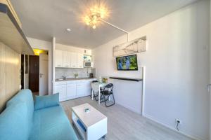 a living room with a blue couch and a kitchen at Blue Beach in Roquebrune-Cap-Martin