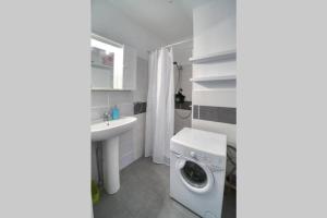 a bathroom with a washing machine and a sink at Blue Beach vue Mer Clim Wifi in Roquebrune-Cap-Martin