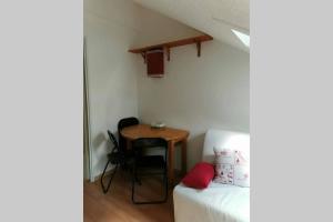 ein kleines Zimmer mit einem Tisch und einem Bett in der Unterkunft Studio mansardé 18 m2 climatisé avec piscine privée in Gresse-en-Vercors