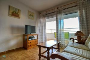 a living room with a couch and a tv at Urbanova Alicante in El Alted