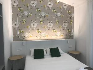 a bedroom with a white bed with a floral wall at Prea Gianca in Bonifacio
