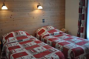 トーヌにあるHôtel et appart'hôtel de l'Hermitageの木製の壁の客室で、ツインベッド2台が備わります。