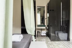 a bedroom with a bed and a bathroom with a mirror at Le Royal in Reggio Calabria