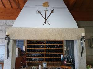 a large clock on a wall above a wine cellar at Hotel Rural Casa de Samaioes in Chaves