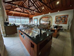 a kitchen with an island in a room with tables at Hotel Rural Casa de Samaioes in Chaves