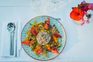 a plate of food on a white table with flowers at Prea Gianca in Bonifacio