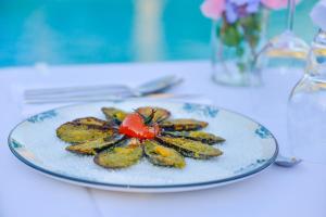 a plate of food with a tomato on a table at Prea Gianca in Bonifacio