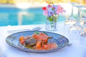a blue plate of food on a table with flowers at Prea Gianca in Bonifacio