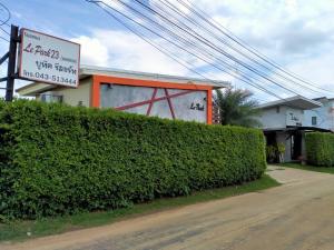 a hedge in front of a building with a sign at Le Park 23 Boutique Resort in Roi Et