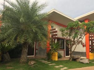 a house with a palm tree in front of it at Le Park 23 Boutique Resort in Roi Et