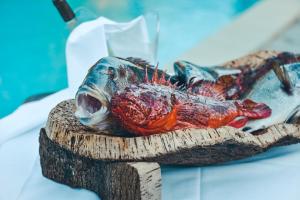 a fish on a wooden stand with a dead fish at Prea Gianca in Bonifacio