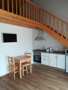 a kitchen with a wooden table and a wooden staircase at Vila Lira in Aljezur