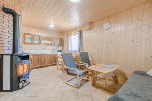 ein Wohnzimmer mit einem Herd, einem Tisch und Stühlen in der Unterkunft Aurum domki in Jarosławiec