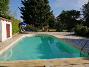 una piscina de agua azul en un patio en Domaine de la Cooloeuvre, en Courthézon