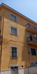 a yellow building with two windows and two balconies at Appartamento Risoli GP in Scalea