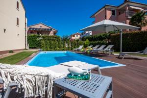 een zwembad met een tafel en stoelen en een parasol bij Villa Francesco in Rovinj