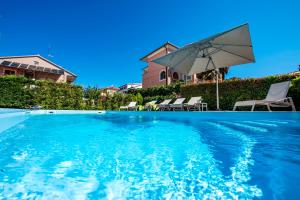 een zwembad met een parasol en stoelen bij Villa Francesco in Rovinj