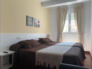 1 dormitorio con 2 camas y ventana en SCQ homes, en Santiago de Compostela
