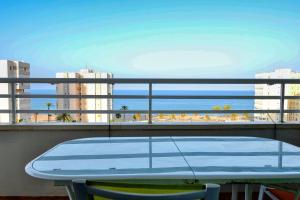 a table on a balcony with a view of the ocean at Urbanova Alicante in El Alted