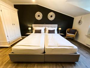 two beds in a bedroom with a black wall at Boutique Apartment Anne in Bad Harzburg