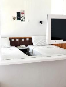 a bedroom with two beds and a flat screen tv at Kekova Hotel in Kaş