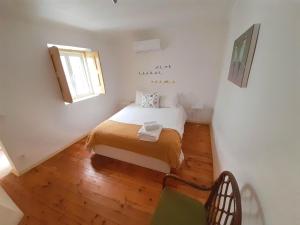 a bedroom with a bed, desk and a lamp at Casas de Alcamim in Elvas