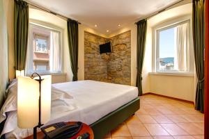 a bedroom with a bed and a stone wall at Residence San Giusto in Trieste