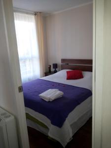 a bedroom with a bed with two towels on it at Departamento Viña del Mar Viana in Viña del Mar