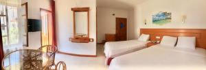 a hotel room with two beds and a television at Kekova Hotel in Kaş