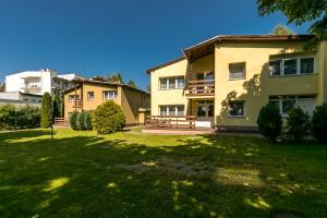 a large house with a lawn in front of it at Apartamenty pod Modrzewiem in Ustronie Morskie