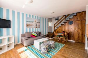a living room with a couch and a table at Apartamenty pod Modrzewiem in Ustronie Morskie