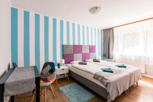 a bedroom with a bed and a striped wall at Apartamenty pod Modrzewiem in Ustronie Morskie