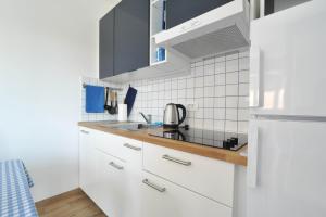 a kitchen with white cabinets and a white refrigerator at Apartmani Rebecca in Vir +43 photos
