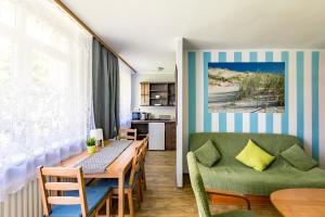 a dining room and kitchen with a table and chairs at Apartamenty pod Modrzewiem in Ustronie Morskie