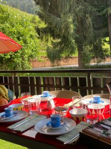 a table with a red table cloth and plates of food at The little Nest in Artogne
