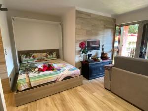 a bedroom with a large bed and a television at The little Nest in Artogne