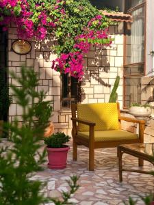 a yellow chair sitting on a patio with pink flowers at Kekova Hotel in Kaş