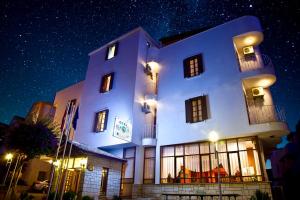 a large white building with windows at night at Kekova Hotel in Kaş