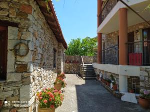 un edificio de piedra con macetas al costado. en Morfili Villa en Limenaria