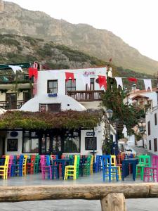 a group of colorful chairs and tables in front of a building at Kekova Hotel in Kaş