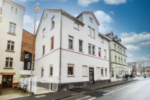 un edificio bianco sul lato di una strada di Hotel Tusculum a Marburg an der Lahn