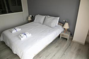 Volos Port View Apartment في فولوس: غرفة نوم بسرير ابيض عليها منشفتين